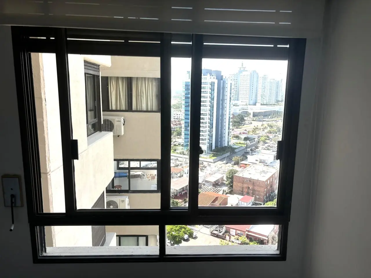 Ventana de aluminio negro con vista a la ciudad