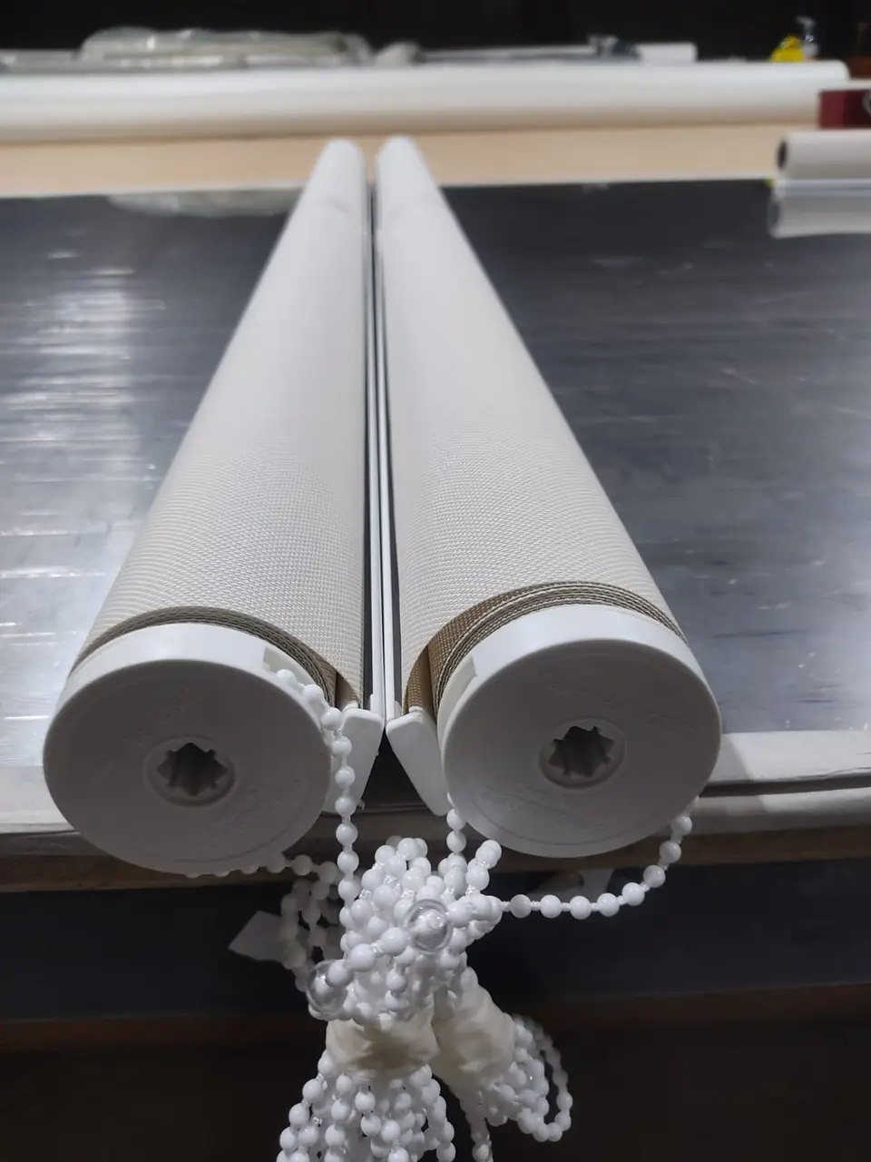 Telas de cortinas roller enrolladas con su cadena, listas para instalar