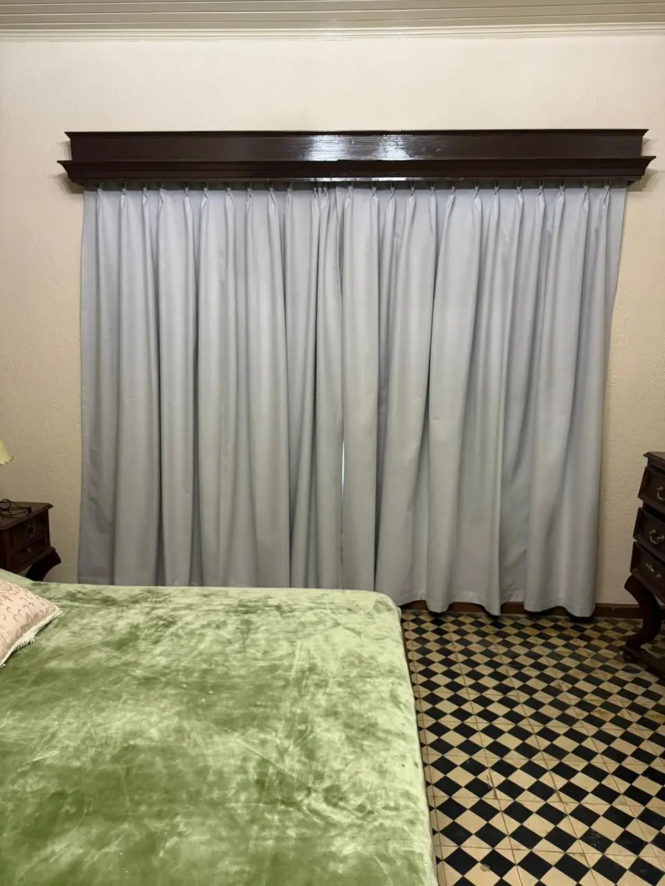Cortina tradicional de tela con galería de madera en un dormitorio